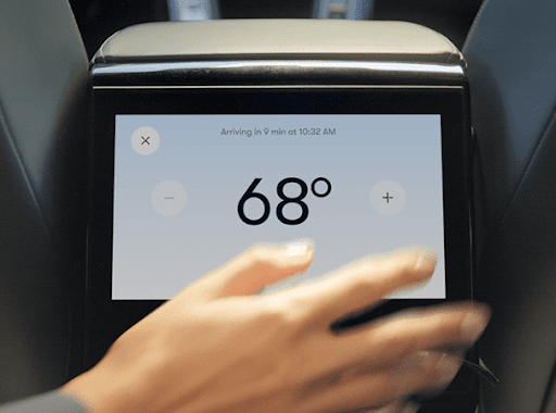 一位女士在车载中控台上调高和调低温度。