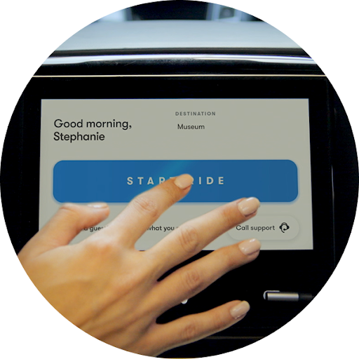 一位女士在车载中控台上点按“开始行程”，并查看行程的路线进度。